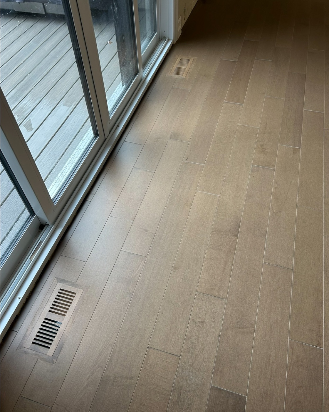 Light oak wide plank hardwood flooring in a finished room