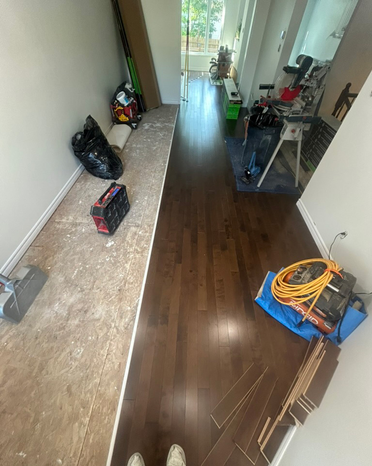 Dark hardwood floor installation in progress through a residential interior in Ottawa
