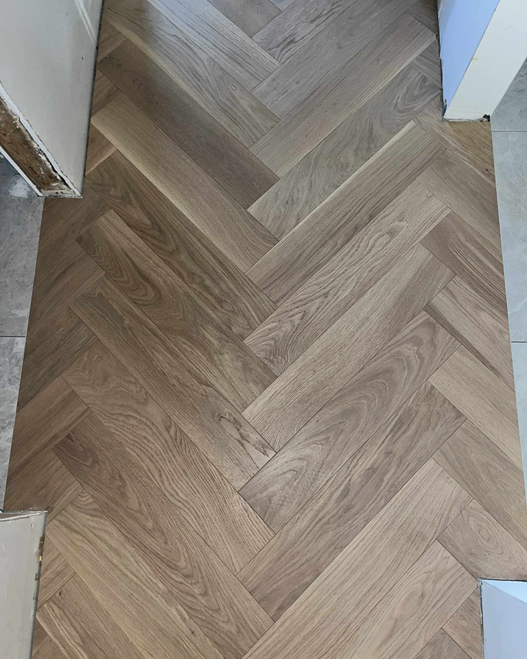 Close view of light oak herringbone flooring with precise pattern alignment in an Ottawa home