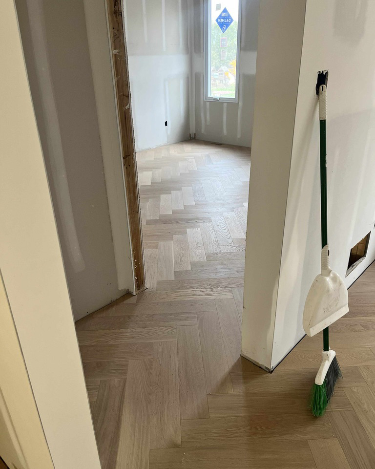 Light oak herringbone hardwood flooring installed through adjoining rooms in an Ottawa home